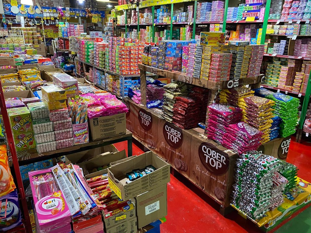 Interior da loja com variedade de doces e produtos organizados em prateleiras